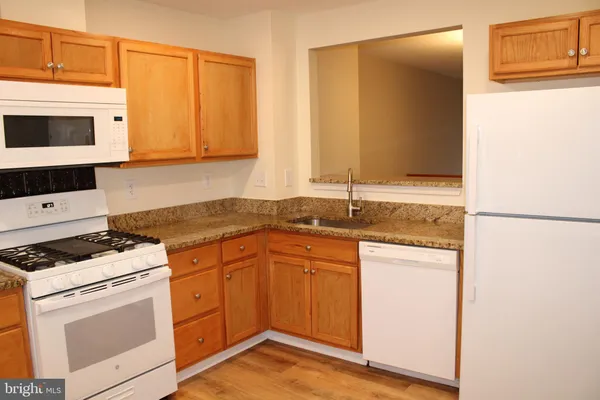 a kitchen with granite countertop cabinets stainless steel appliances and a counter space
