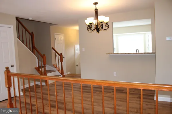 a view of a livingroom with wooden floor and stairs