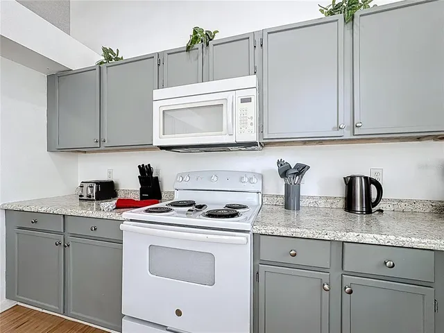 a kitchen with granite countertop a sink stainless steel appliances and cabinets