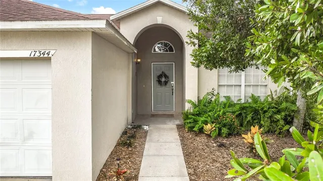 a view of a small house with a clock and a potted plant