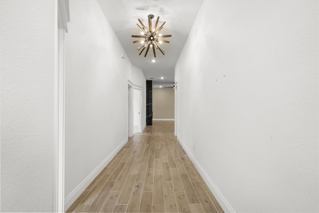 1868 Meadowview Canton, TX 75103 - Photo 12 of 40 a view of a hallway with wooden floor and a chandelier