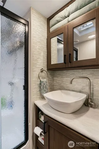 a bathroom with a granite countertop sink and a mirror