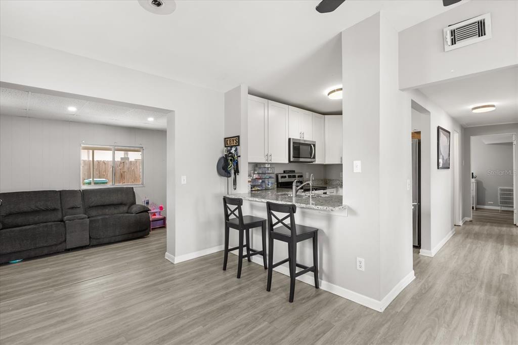 609 East Highland Street Altamonte Springs, FL 32701 - Photo 7 of 35 a kitchen with stainless steel appliances kitchen island granite countertop a refrigerator and microwave