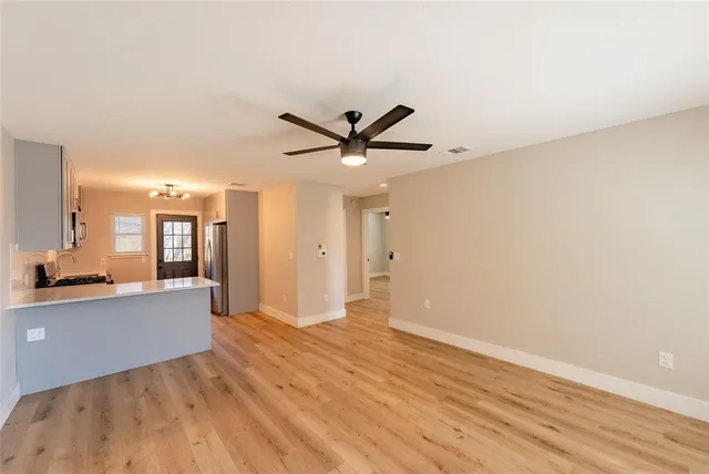 a view of a livingroom with a hardwood floor and a ceiling fan