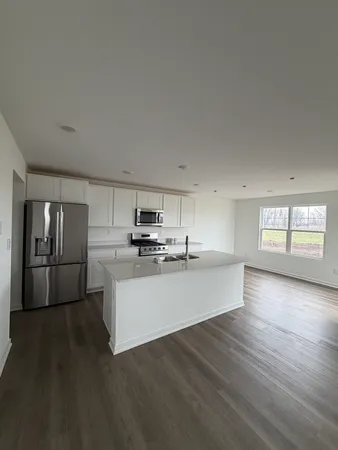 a kitchen with a refrigerator and a stove top oven