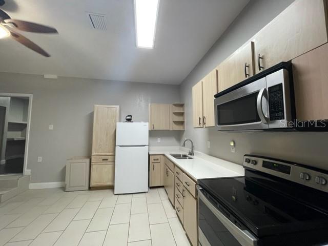 704 Southwest 6th Street Okeechobee, FL 34974 - Photo 17 of 21 a kitchen with a sink stainless steel appliances and cabinets