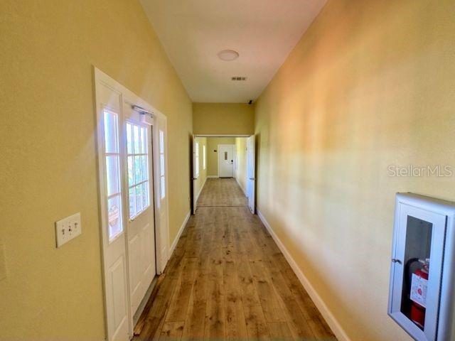 704 Southwest 6th Street Okeechobee, FL 34974 - Photo 2 of 21 a view of a hallway with wooden floor and staircase