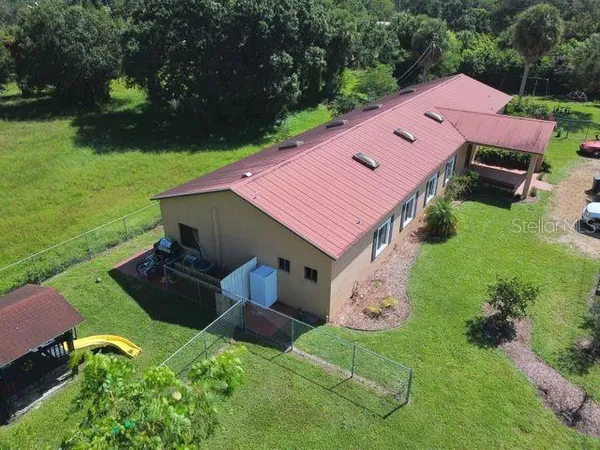 an aerial view of a house with garden space and a patio