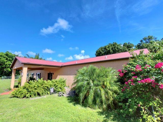 704 Southwest 6th Street Okeechobee, FL 34974 - Photo 7 of 21 a view of a house with a big yard and potted plants