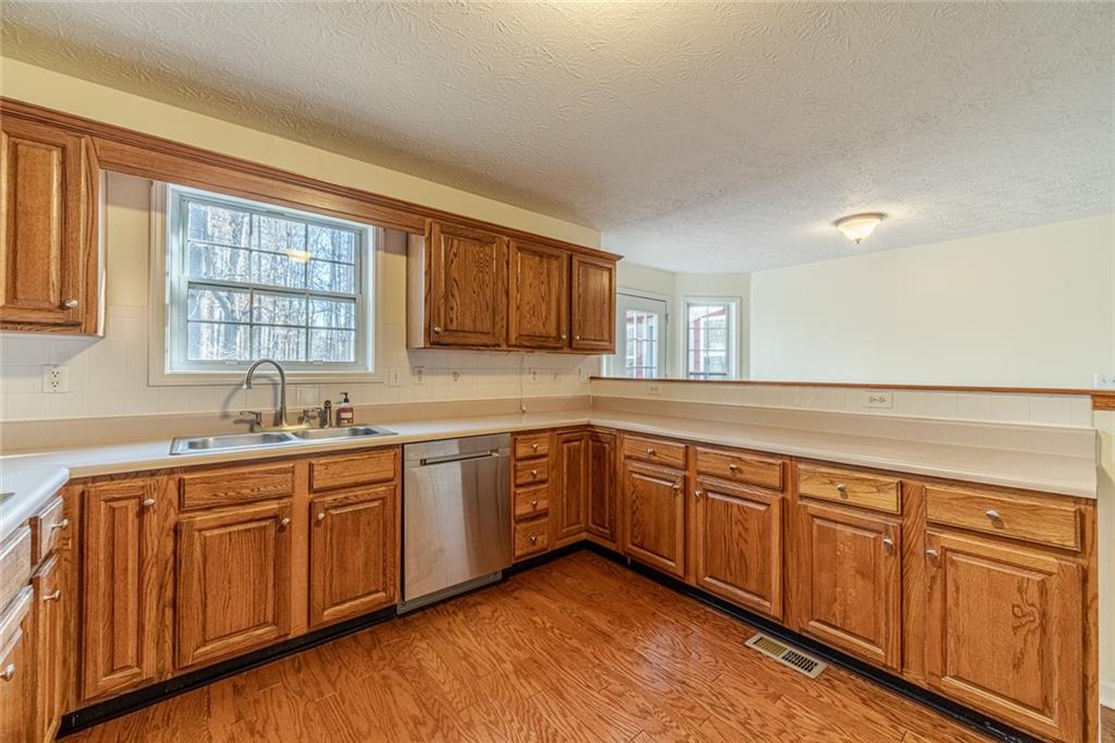 3240 Stewart Lake Road Monroe, GA 30655 - Photo 12 of 68 a kitchen with sink and wooden cabinets