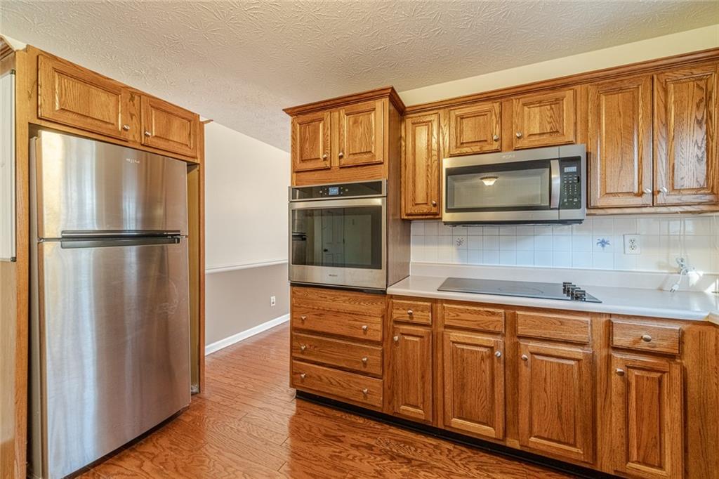 3240 Stewart Lake Road Monroe, GA 30655 - Photo 14 of 68 a kitchen with stainless steel appliances granite countertop a refrigerator microwave and sink