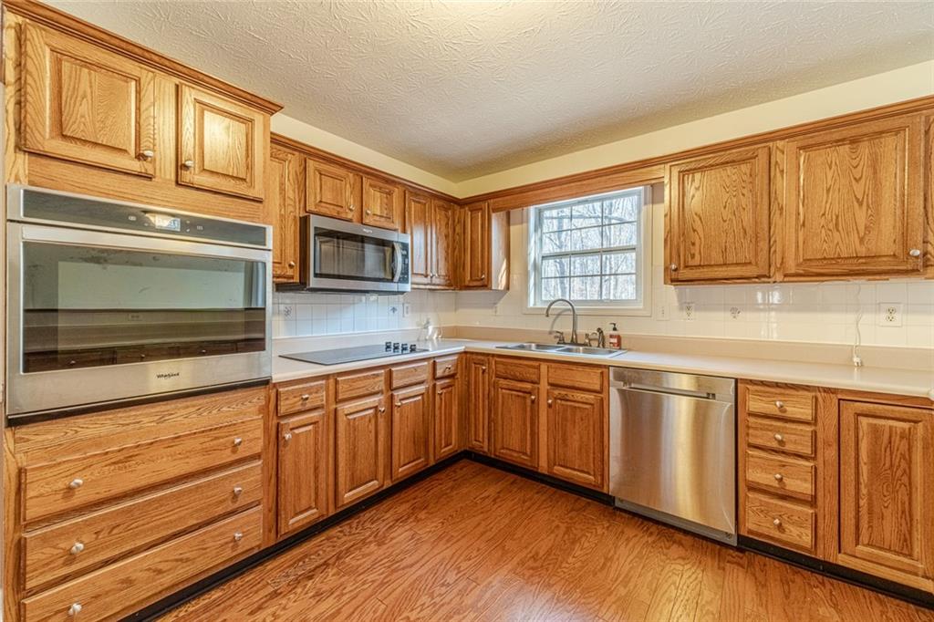 3240 Stewart Lake Road Monroe, GA 30655 - Photo 15 of 68 a kitchen with stainless steel appliances granite countertop wooden cabinets a sink and a stove