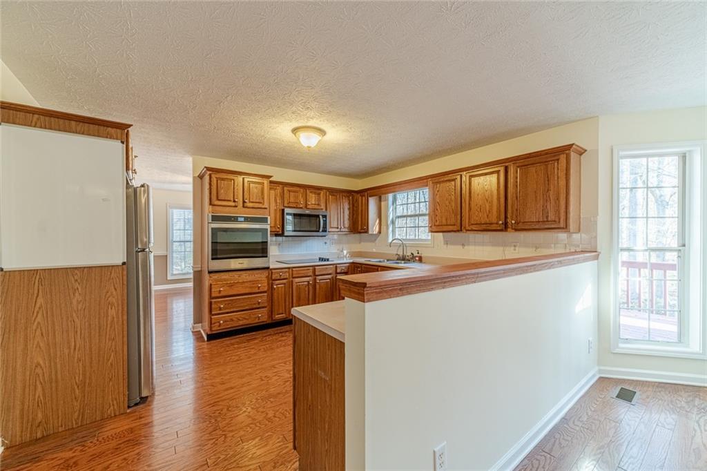 3240 Stewart Lake Road Monroe, GA 30655 - Photo 17 of 68 a kitchen with stainless steel appliances a refrigerator and a stove top oven