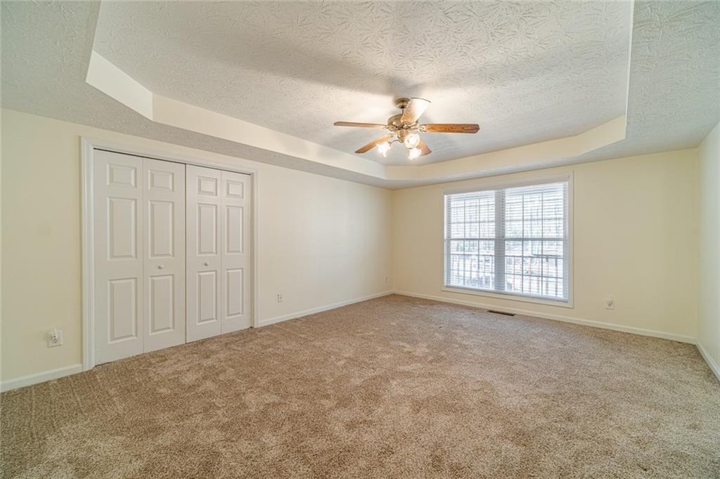 3240 Stewart Lake Road Monroe, GA 30655 - Photo 25 of 68 an empty room with windows and ceiling fan