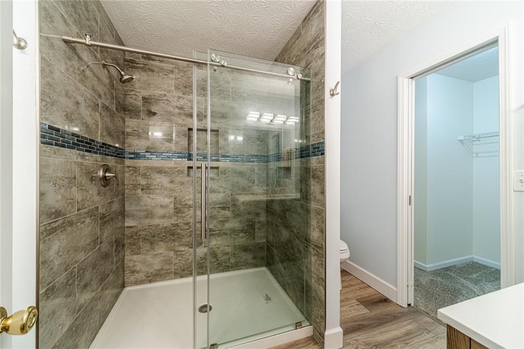 3240 Stewart Lake Road Monroe, GA 30655 - Photo 28 of 68 a bathroom with a glass shower door