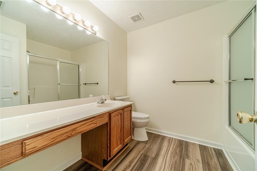 3240 Stewart Lake Road Monroe, GA 30655 - Photo 36 of 68 a spacious bathroom with a sink a toilet a mirror and shower