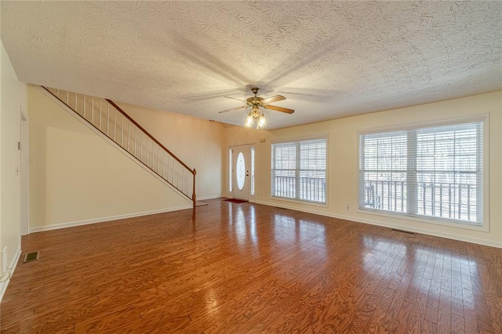 3240 Stewart Lake Road Monroe, GA 30655 - Photo 8 of 68 a view of an empty room with wooden floor and a window