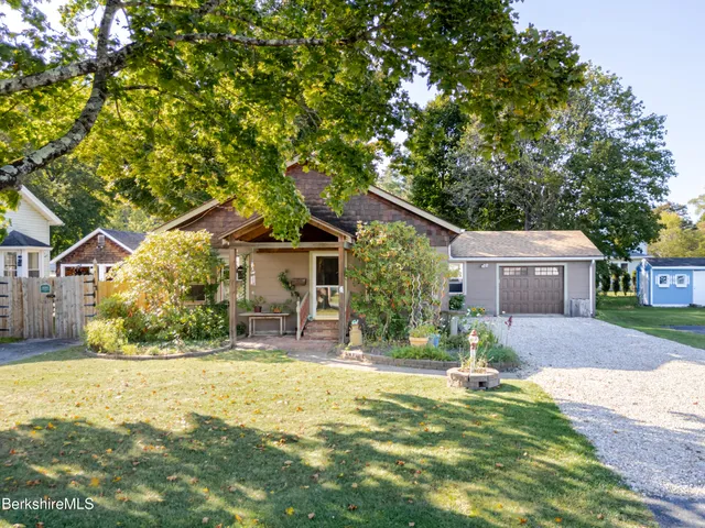 a front view of house with yard and trees in the background