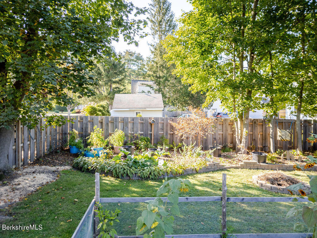 6 Locust Street Great Barrington, MA 01230 - Photo 31 of 36 a view of a garden with a bench and trees