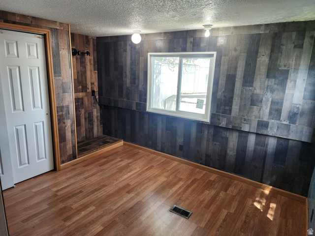 332 Joshua Street Tooele, UT 84074 - Photo 3 of 16 Interior room featuring wood-finish flooring and paneled walls
