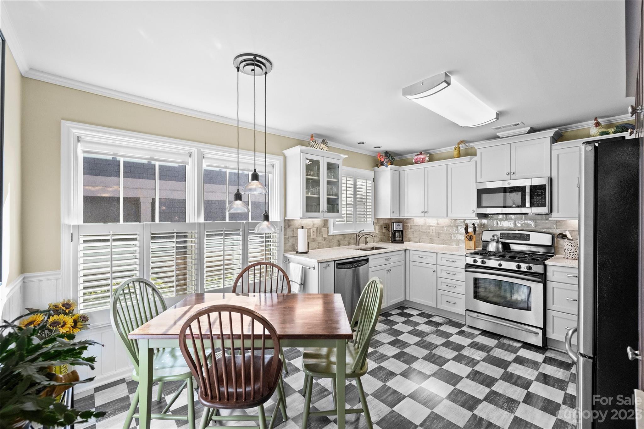 711 Romany Road Charlotte, NC 28203 - Photo 8 of 28 a kitchen with stainless steel appliances a dining table chairs stove refrigerator and cabinets