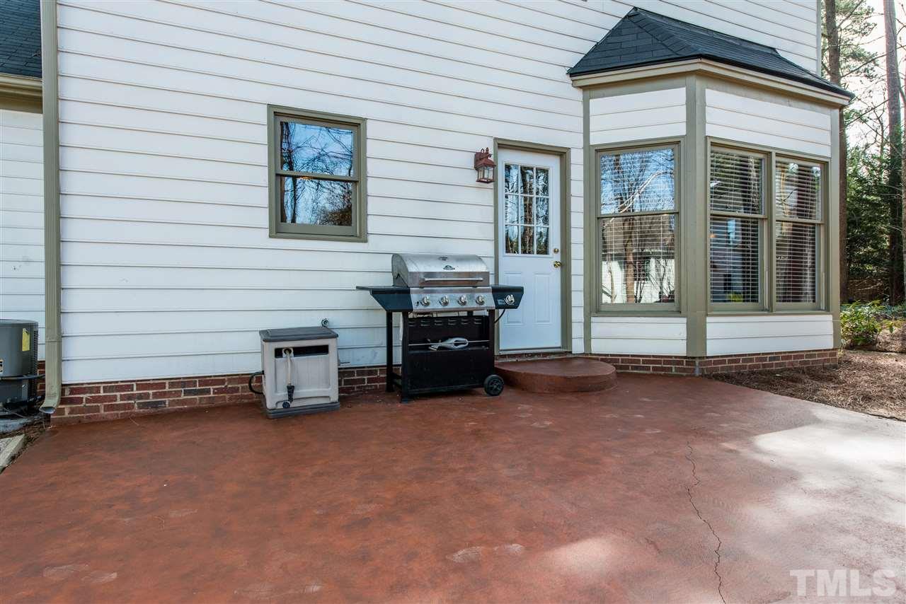 5504 Edgebury Road Raleigh, NC 27613 - Photo 21 of 25 a view of a house with a barbeque and large trees