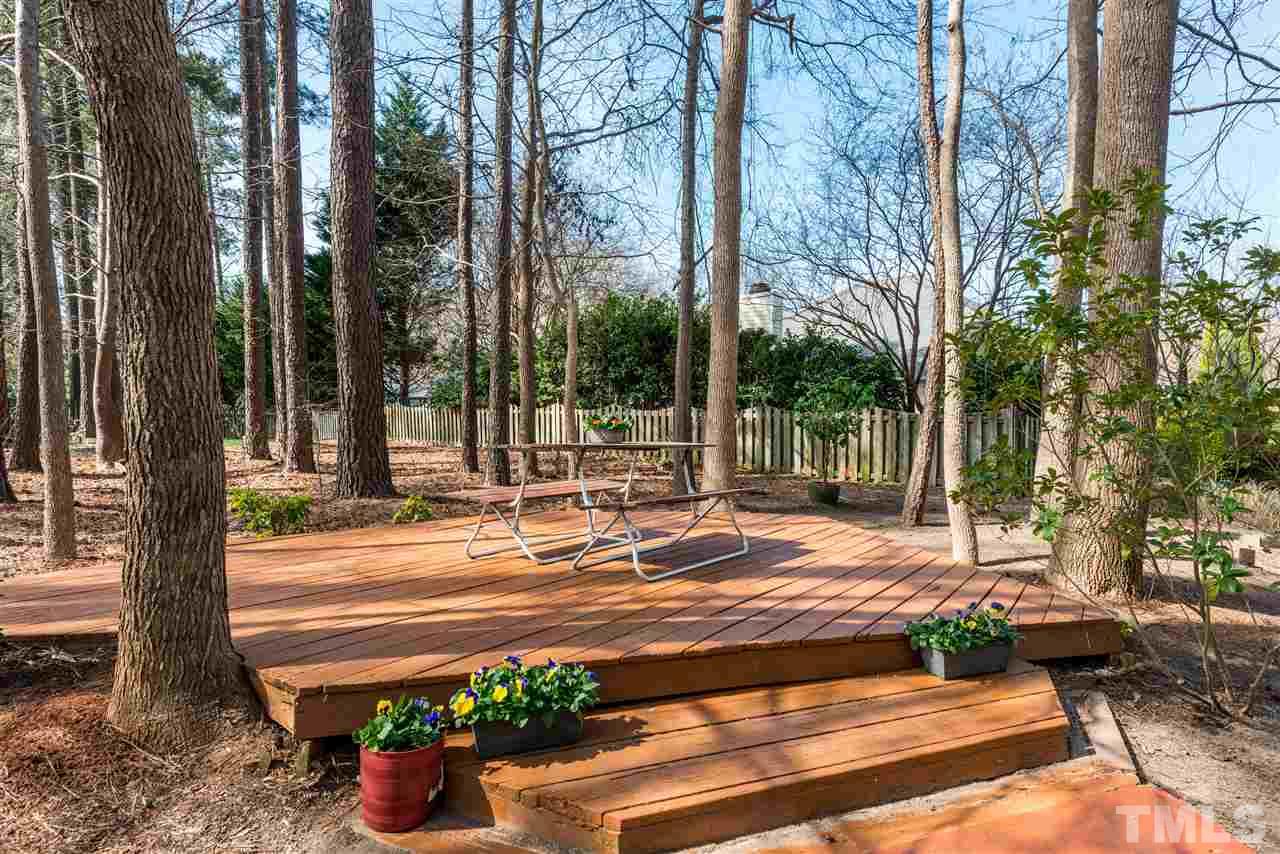5504 Edgebury Road Raleigh, NC 27613 - Photo 23 of 25 a view of a patio with a table and chairs and a large tree