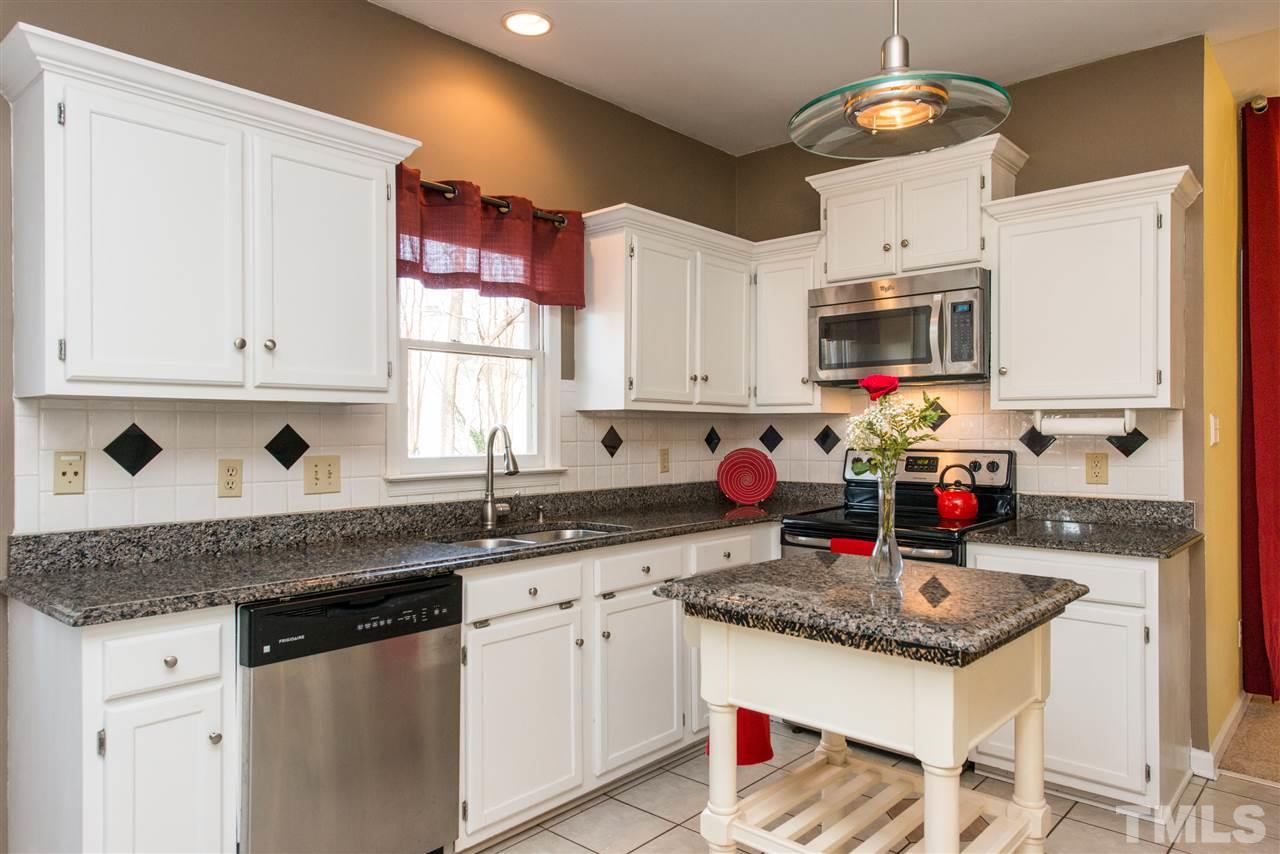5504 Edgebury Road Raleigh, NC 27613 - Photo 10 of 25 a kitchen with granite countertop a sink stainless steel appliances and white cabinets