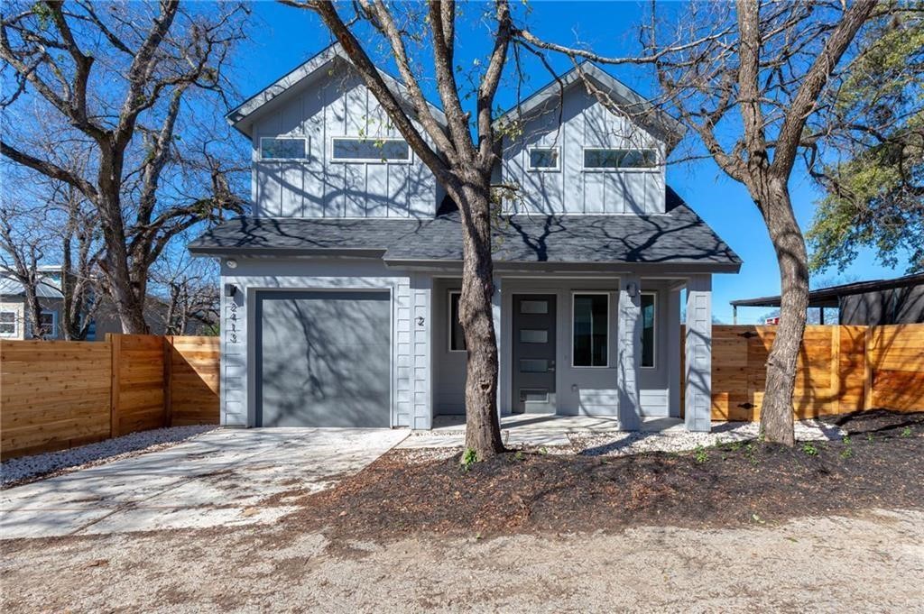 View of front of home with a porch, driveway, board and batten siding, and an attached garage