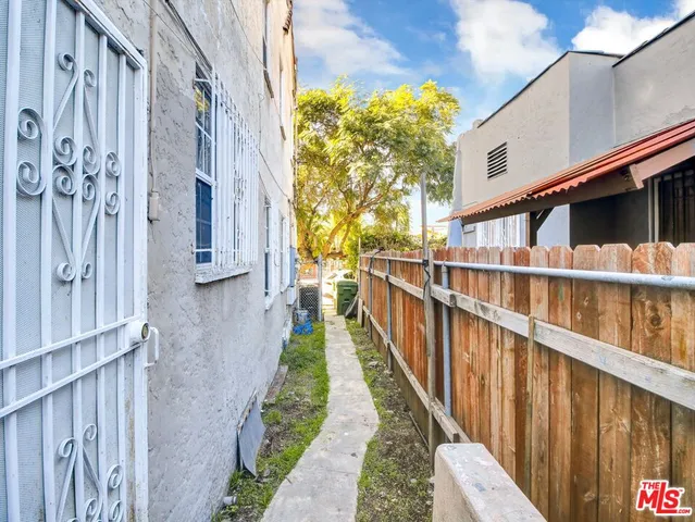 a view of a pathway of a house with wooden fence