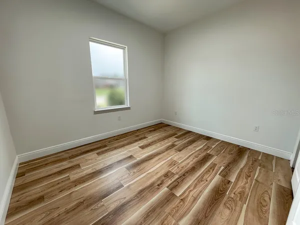 a view of a room with wooden floor and window