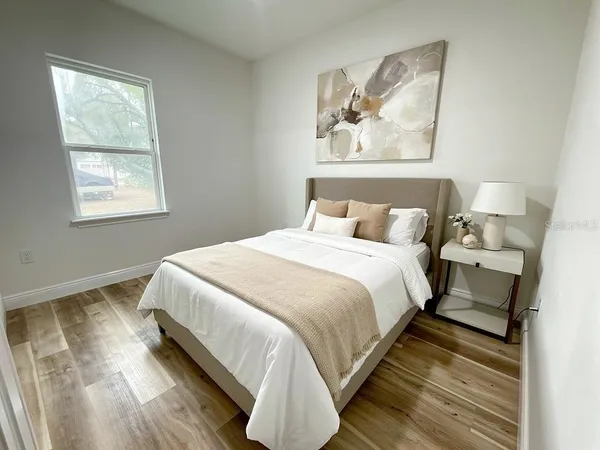 a bedroom with bed and wall painting with wooden floor