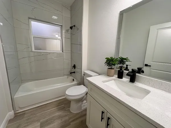 a bathroom with a sink a mirror a toilet and bathtub