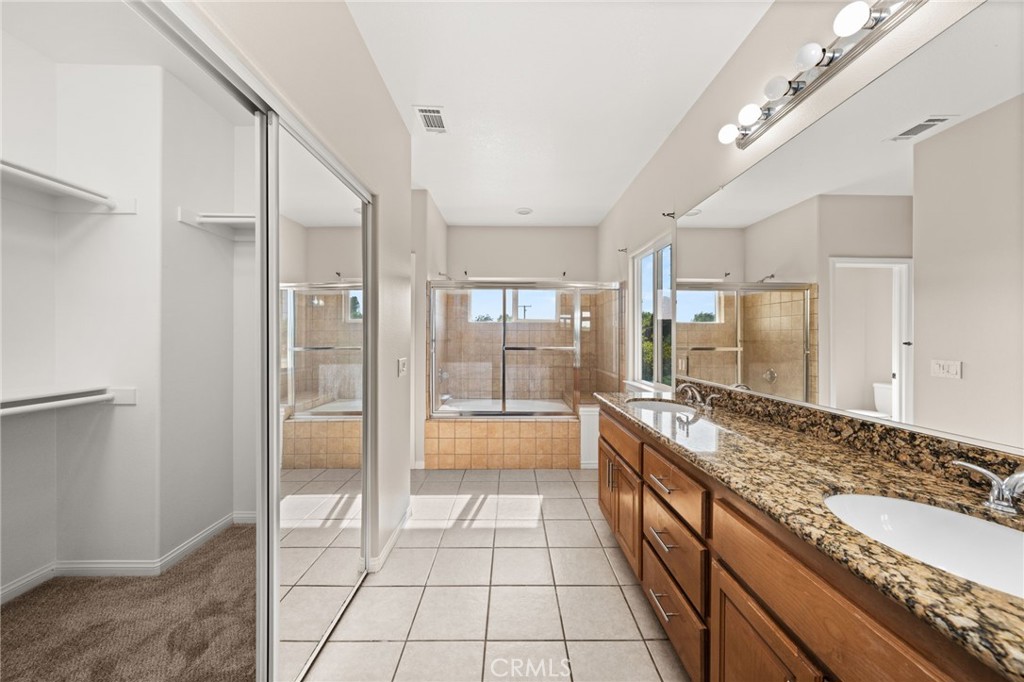 15868 Shorb Street Riverside, CA 92508 - Photo 11 of 15 a large spacious bathroom with a granite countertop tub shower and sink