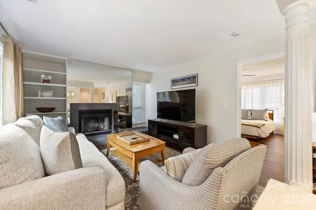 a living room with furniture a fireplace and a flat screen tv