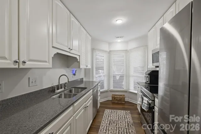 a kitchen with stainless steel appliances a sink stove and cabinets