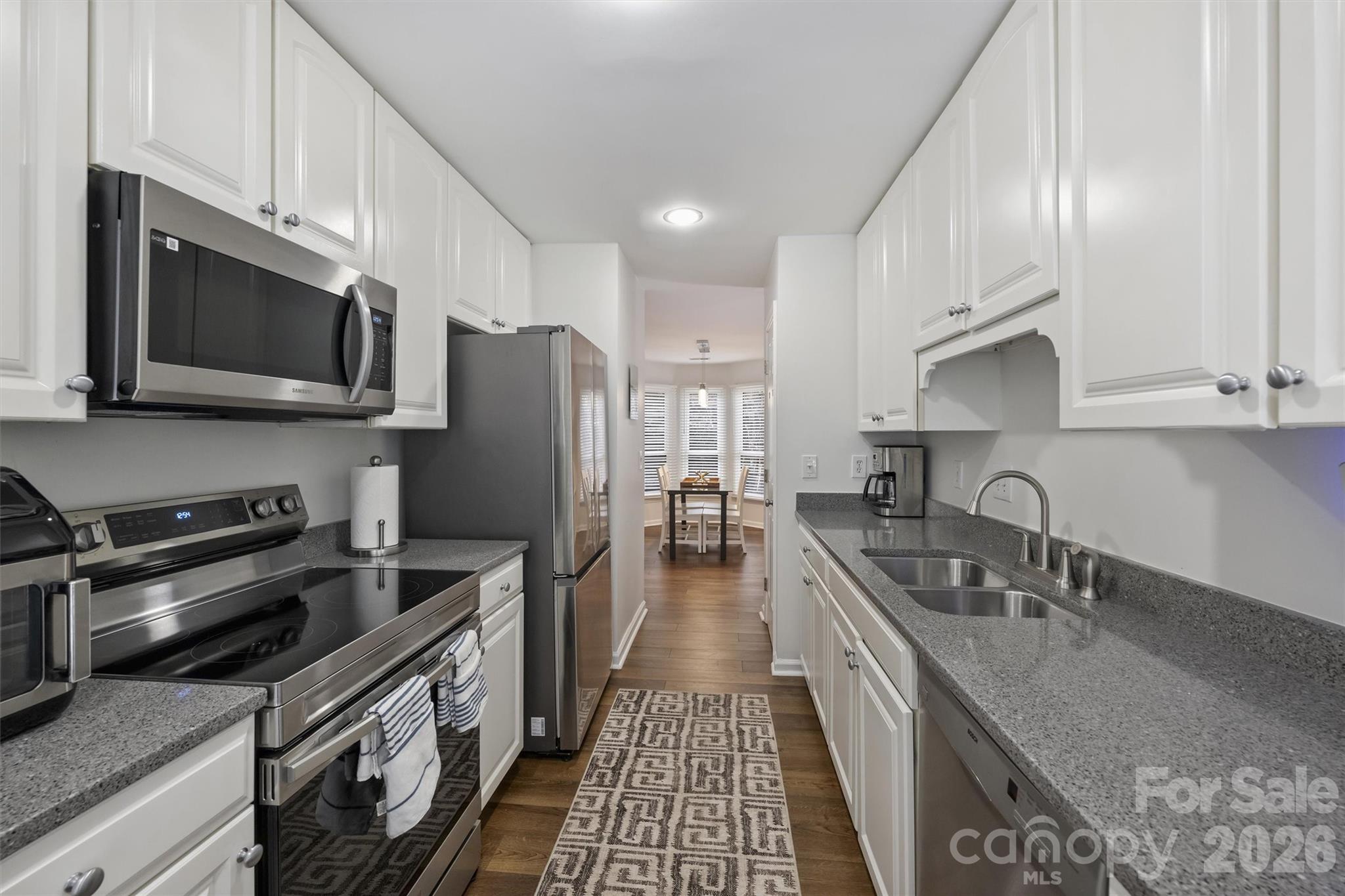 607 Queens Road Charlotte, NC 28207 - Photo 18 of 26 a kitchen with stainless steel appliances granite countertop a sink a stove oven a refrigerator with grey cabinets and wooden floor