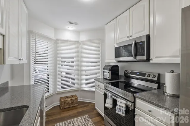 a kitchen with stainless steel appliances a sink a stove a microwave and cabinets