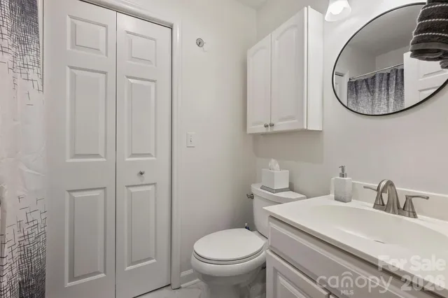 a bathroom with a toilet a sink and mirror