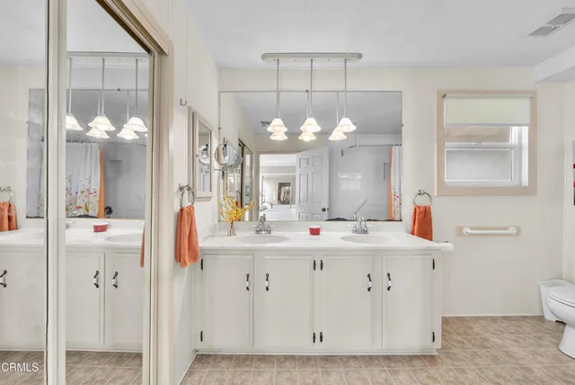 a bathroom with a double vanity sink mirror and