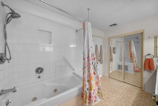 a bathroom with a bathtub a shower and a window