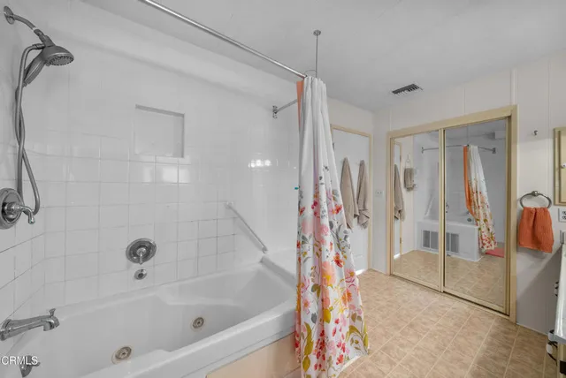 a bathroom with a bathtub a shower and a window