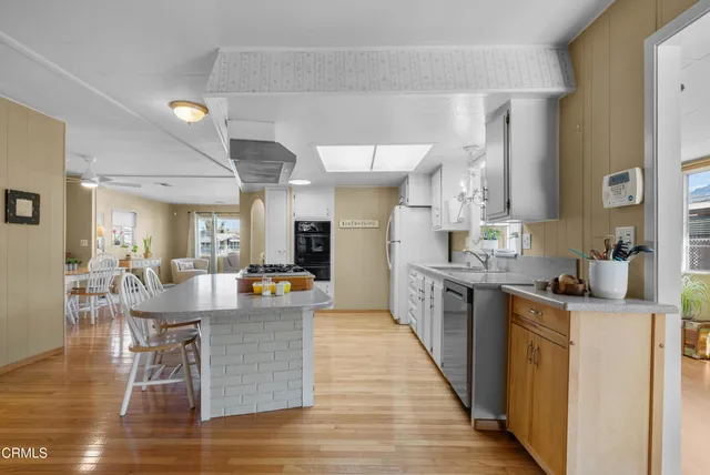 a dining hall with stainless steel appliances granite countertop a stove and kitchen island