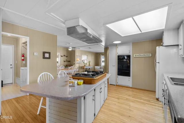 a kitchen with stainless steel appliances granite countertop a refrigerator a stove and a wooden floors