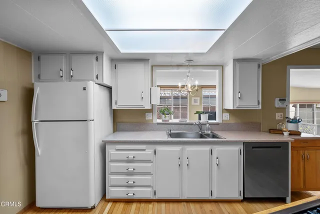 a kitchen with cabinets appliances a sink and a window