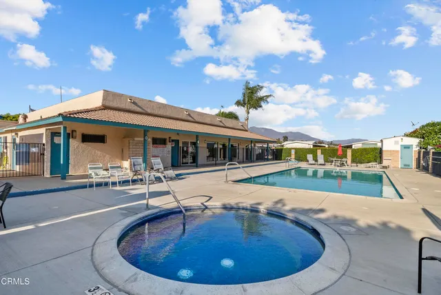 a view of a house with swimming pool and sitting area