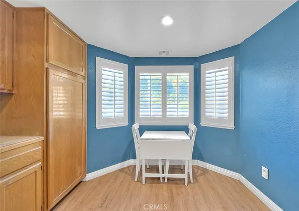 a dining room with wooden floor and a window