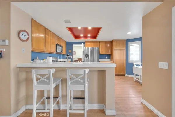 a kitchen with stainless steel appliances kitchen island granite countertop a refrigerator and wooden cabinets