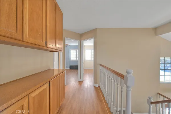 a view of a hallway with wooden floor and staircase