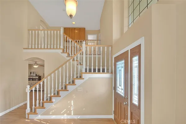 a view of staircase with railing and a chandelier